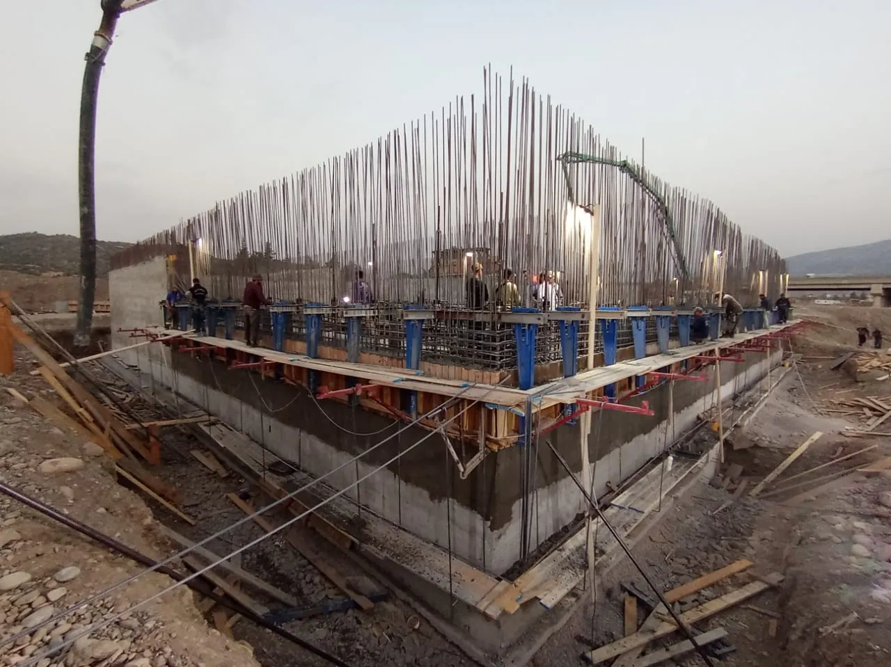 Coffrage glissant en place sur un réservoir, ferraillage en attente et pompe à béton